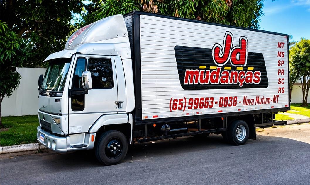 Caminhão baú Ford Cargo 816 da J.D Mudanças em rua arborizada de Nova Mutum